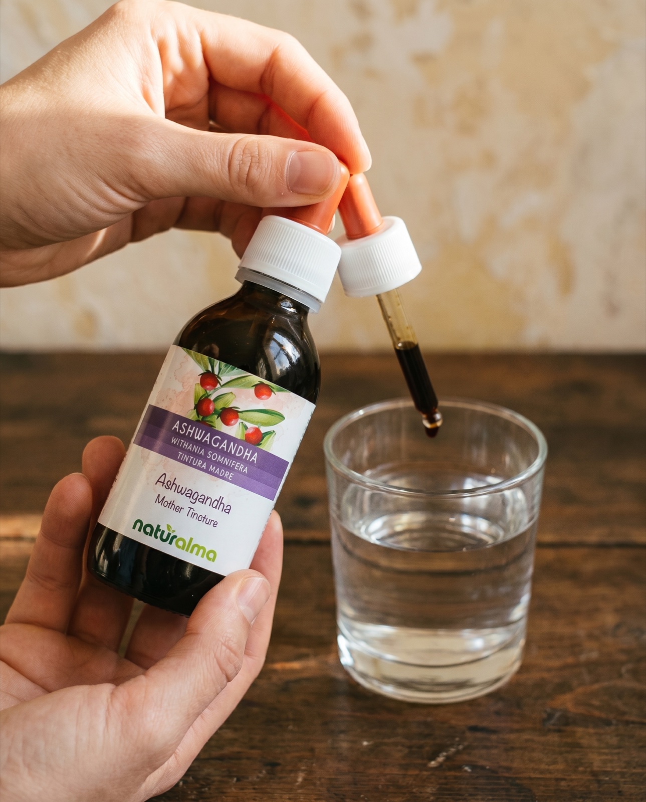Gocce di estratto di ashwagandha versate in un bicchiere d'acqua
